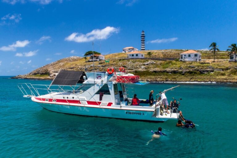 Lancha em Abrolhos com farol ao fundo